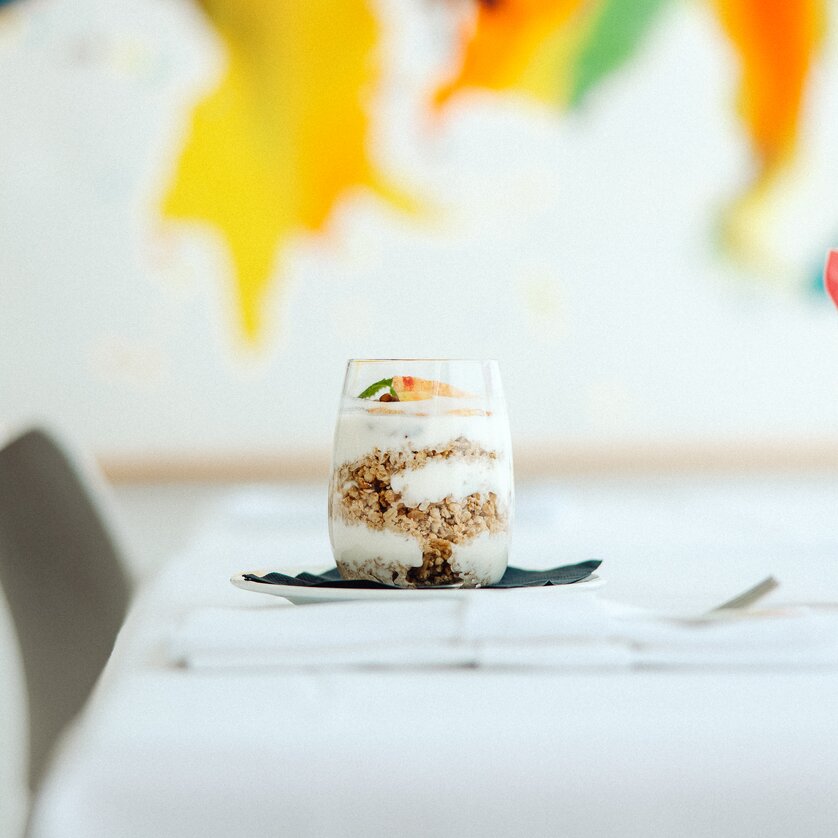 A glass filled with yoghurt, granola and fresh fruit | © Augartenhotel x einsnullneun