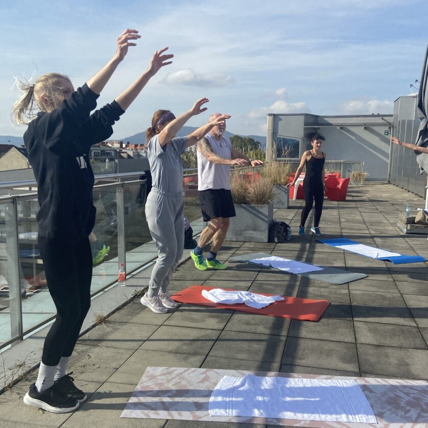 A small group of people jump into the air during a workout | © Alex Eibinger